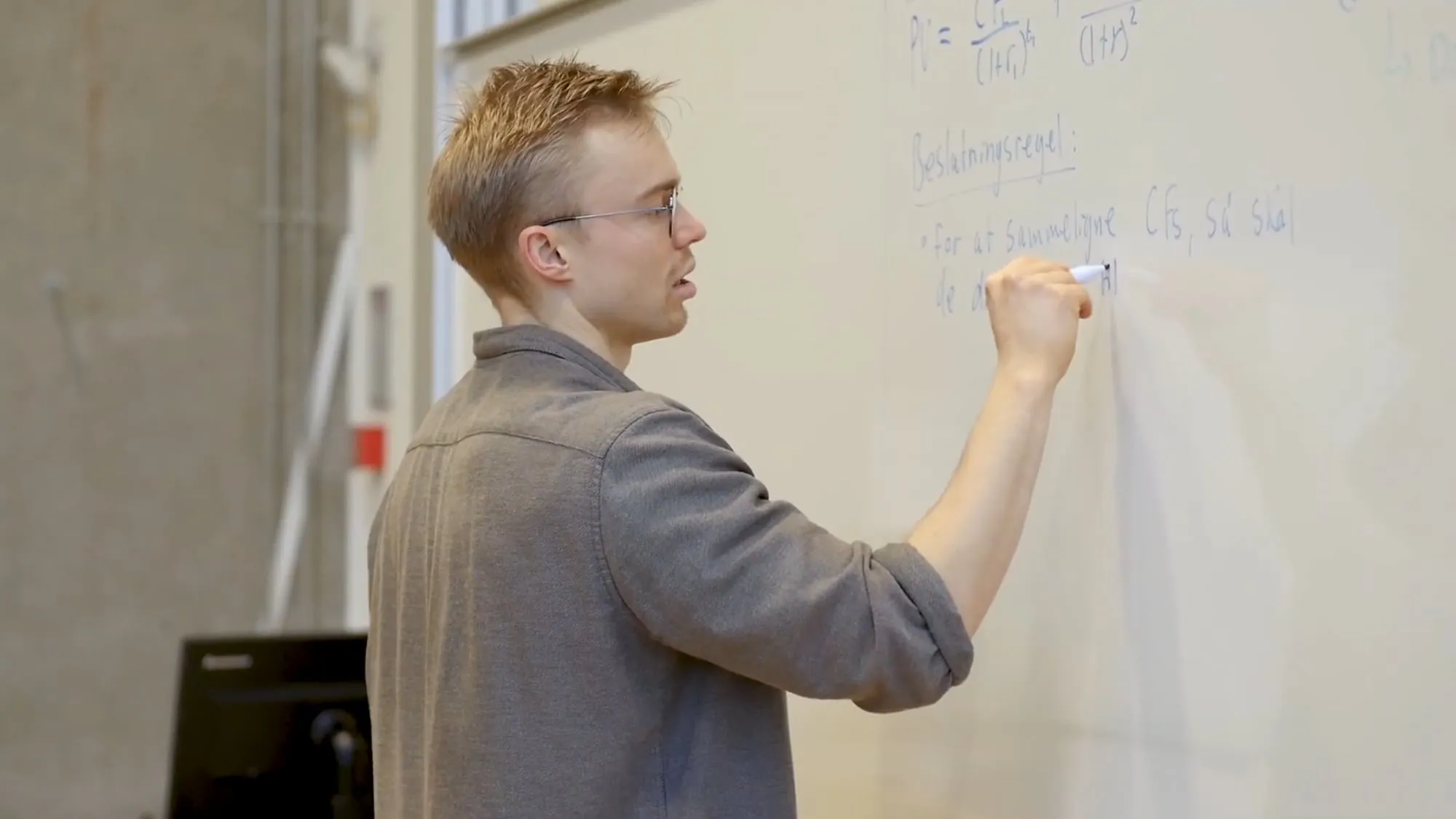 Kim writing on the whiteboard during a lecture